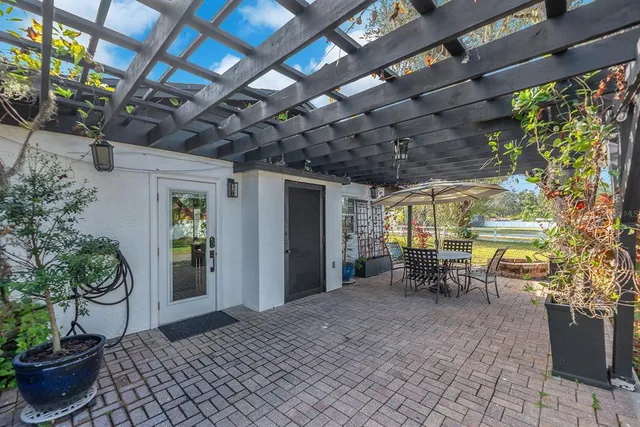 a view of a porch with chairs and potted plants
