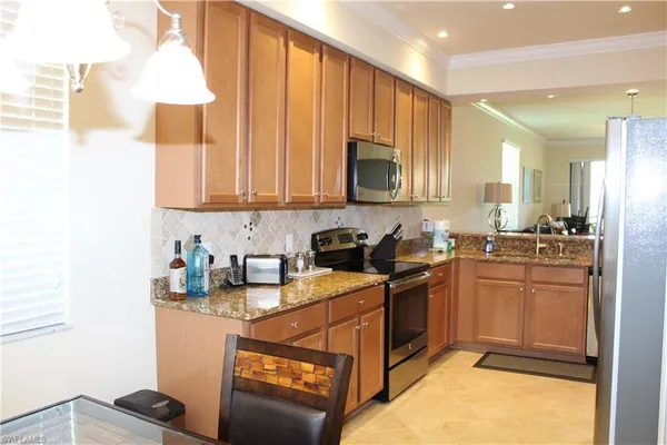 a kitchen with stainless steel appliances granite countertop a stove a sink and a microwave