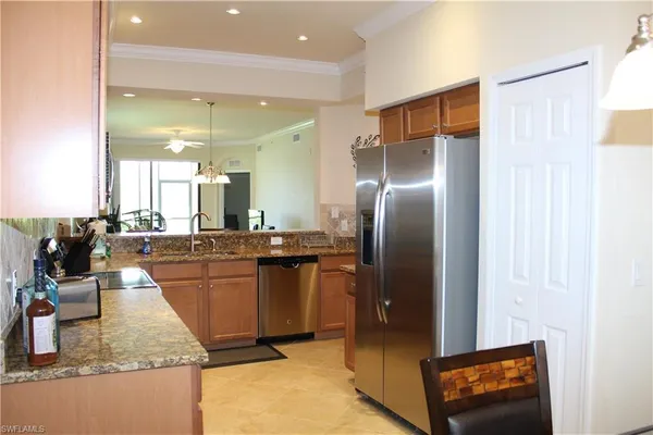 a kitchen with stainless steel appliances granite countertop a refrigerator a oven and a sink