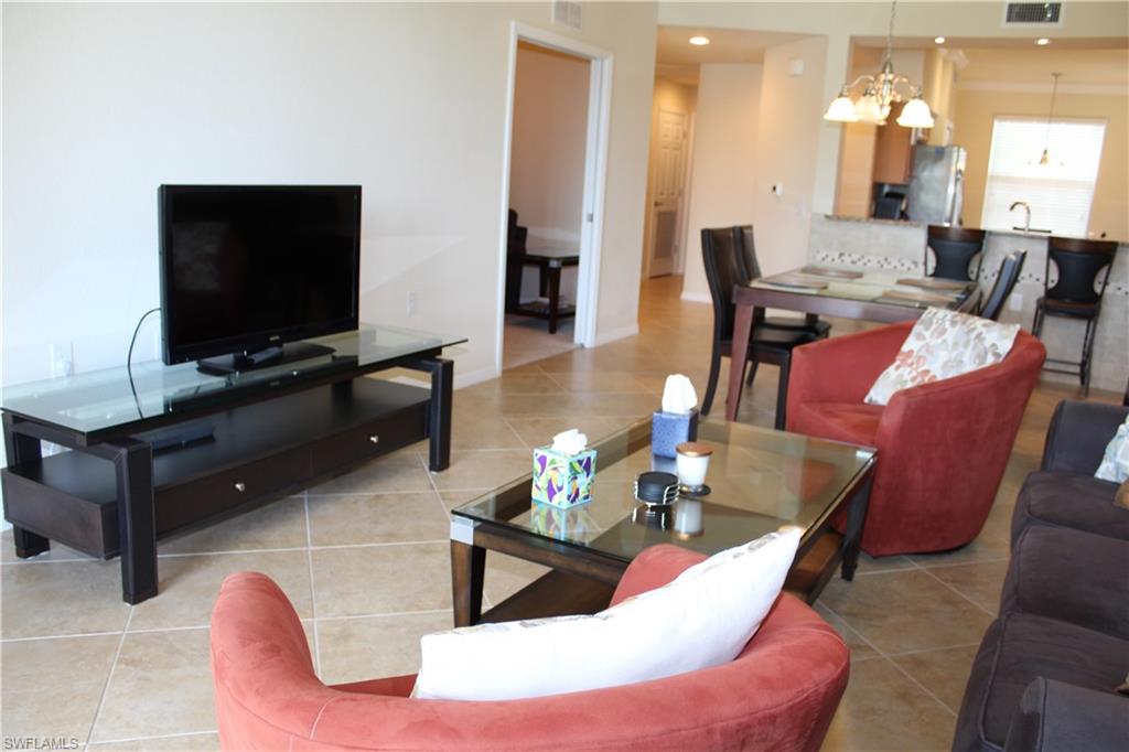 9735 Acqua Court, Unit 611 Naples, FL 34113 - Photo 8 of 30 Living room with light tile patterned flooring, a chandelier, and recessed lighting