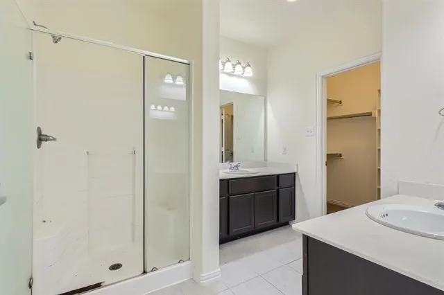 a bathroom with a granite countertop sink a mirror and a shower