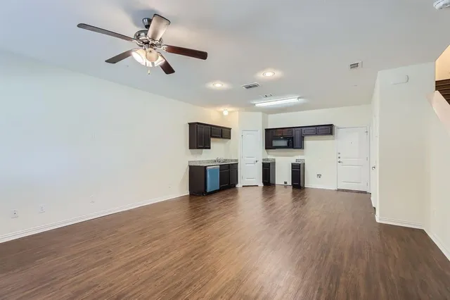 a view of kitchen with microwave and refrigerator