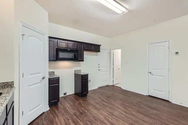 a view of a kitchen with wooden floor and electronic appliances