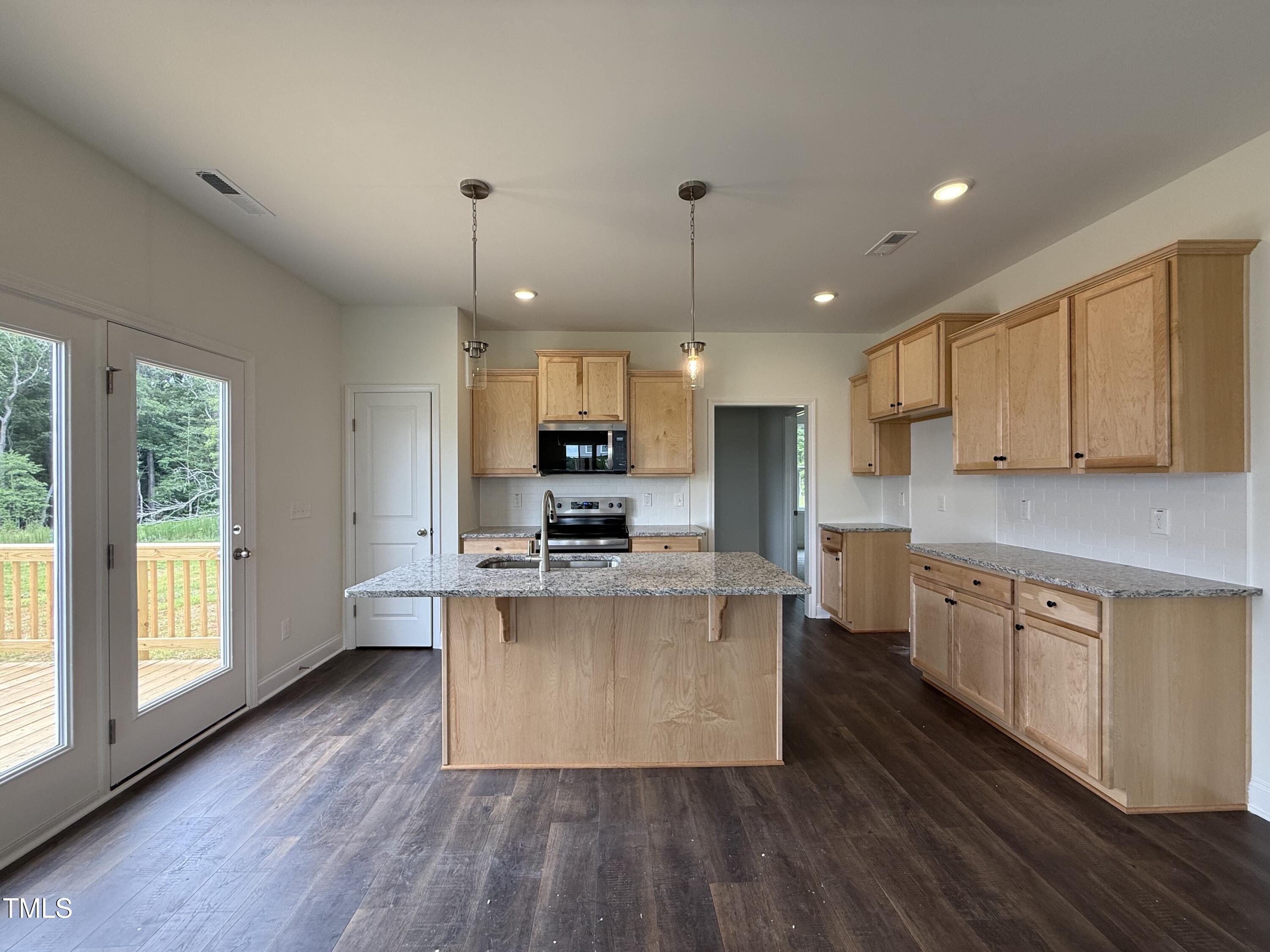 274 Longbow Drive Middlesex, NC 27557 - Photo 13 of 14 a large kitchen with stainless steel appliances granite countertop a stove a sink dishwasher a microwave oven and a wooden cabinets