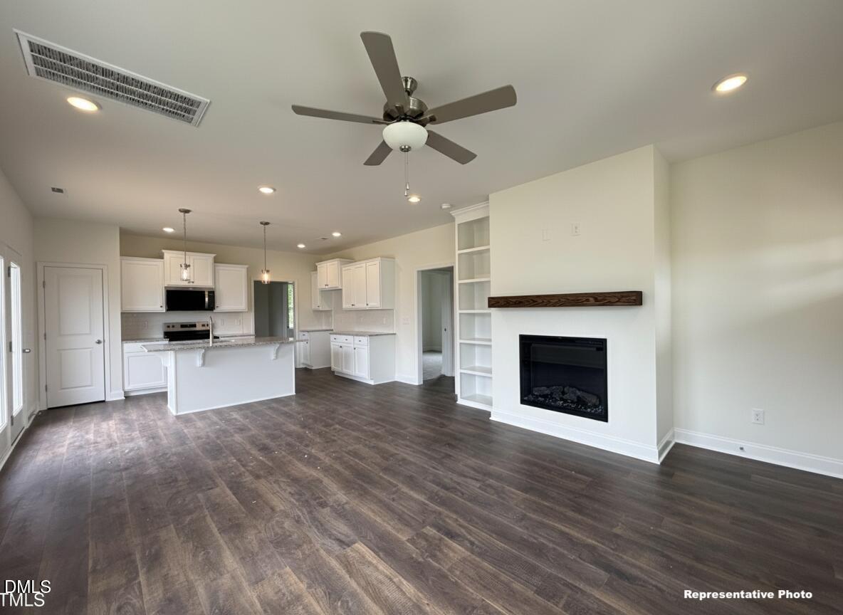274 Longbow Drive Middlesex, NC 27557 - Photo 6 of 14 a view of an empty room with kitchen and fireplace