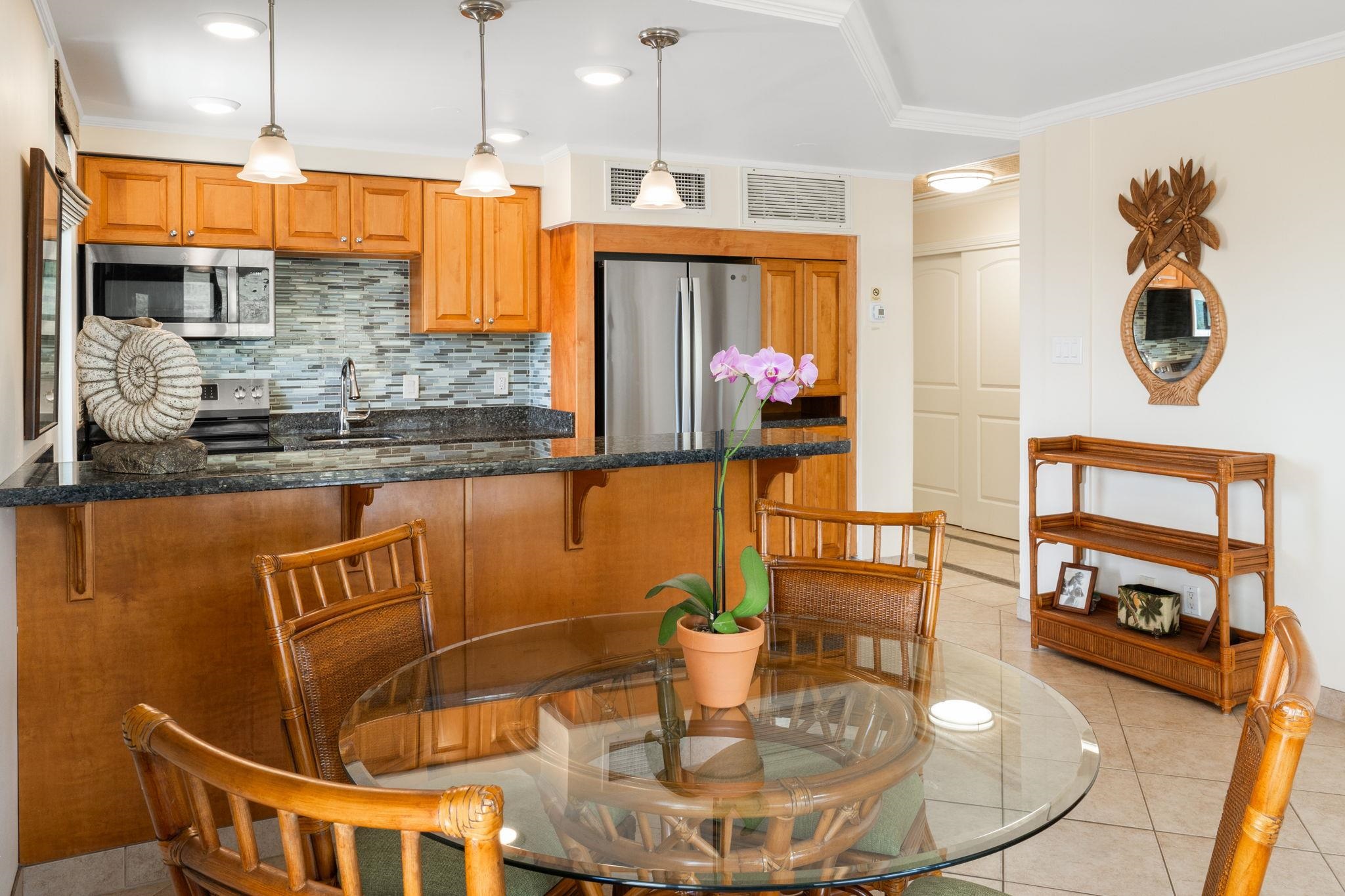 475 Front Street, Unit 402 Lahaina, HI 96761 - Photo 18 of 34 a kitchen with stainless steel appliances wooden floor dining table and chairs