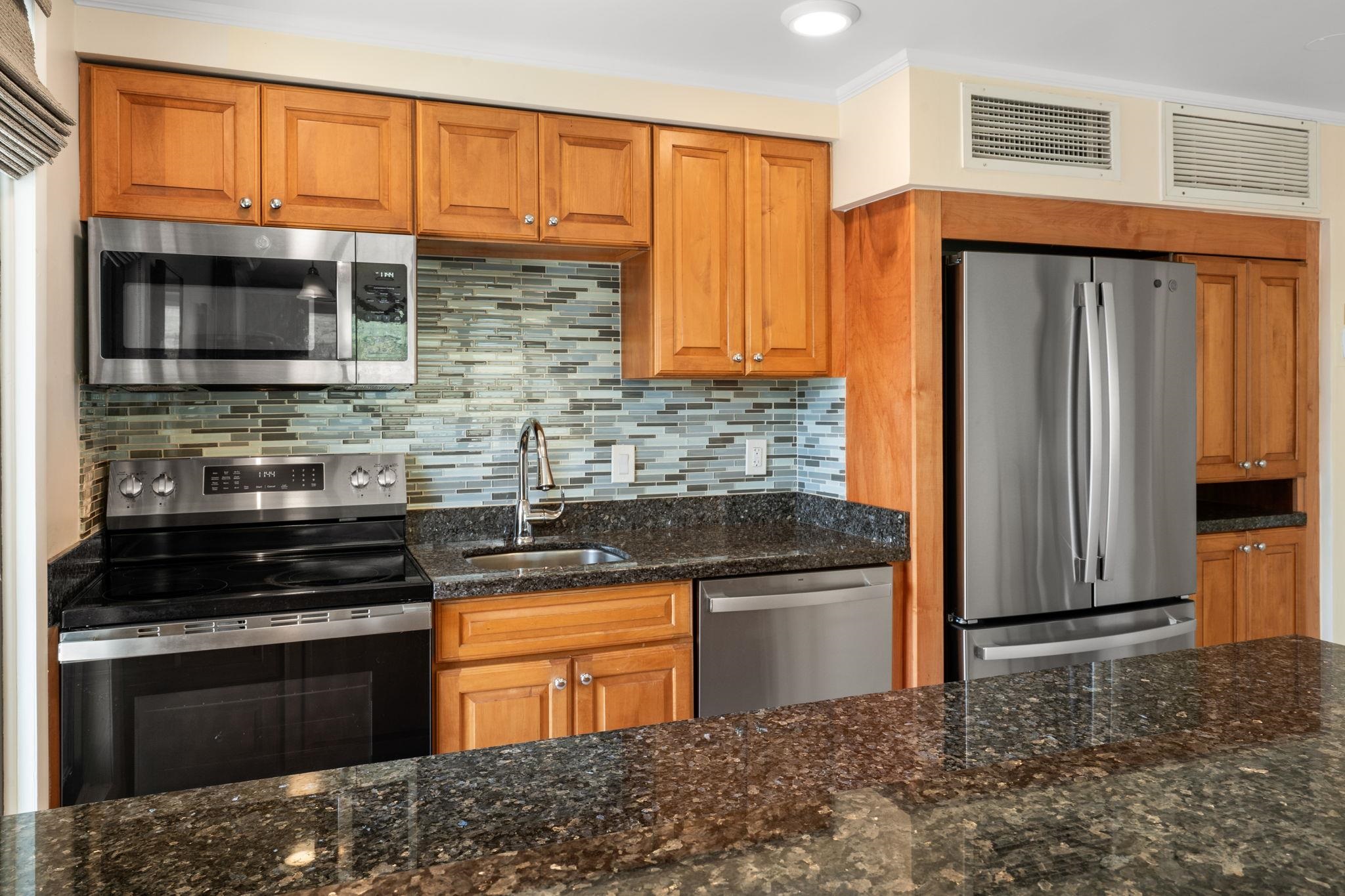 475 Front Street, Unit 402 Lahaina, HI 96761 - Photo 19 of 34 a kitchen with stainless steel appliances granite countertop a stove and a refrigerator