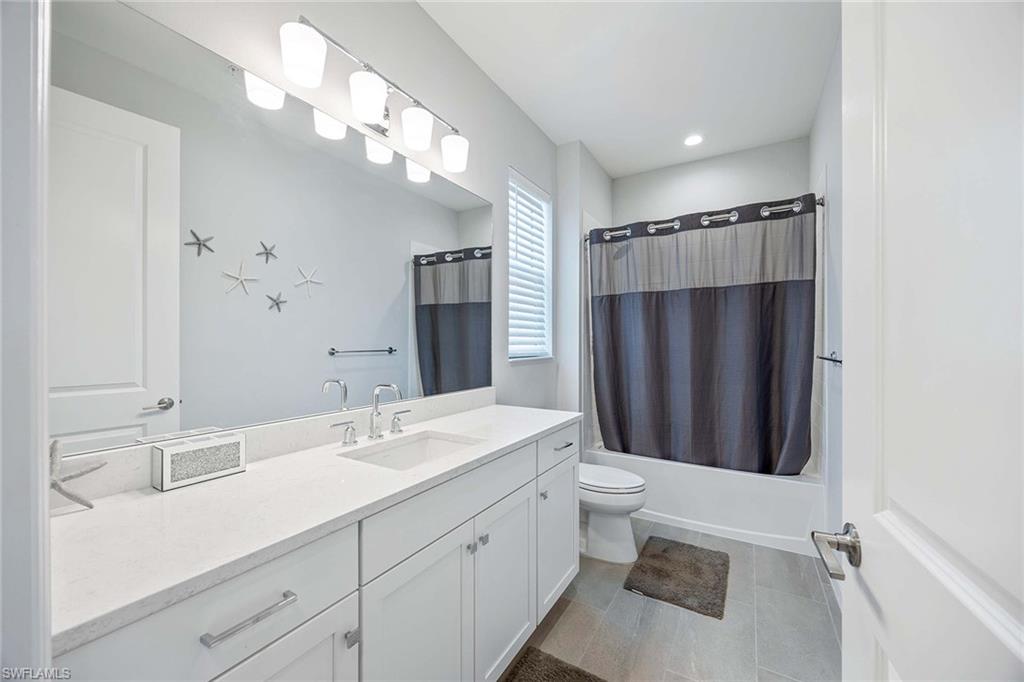2603 Seychelles Circle, Unit 1505 Naples, FL 34112 - Photo 20 of 35 a bathroom with a double vanity sink mirror and toilet