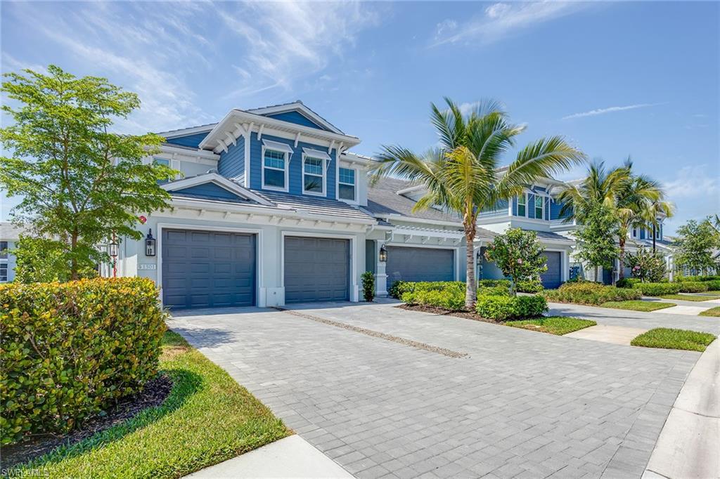 2603 Seychelles Circle, Unit 1505 Naples, FL 34112 - Photo 2 of 35 a front view of a house with a yard and garage