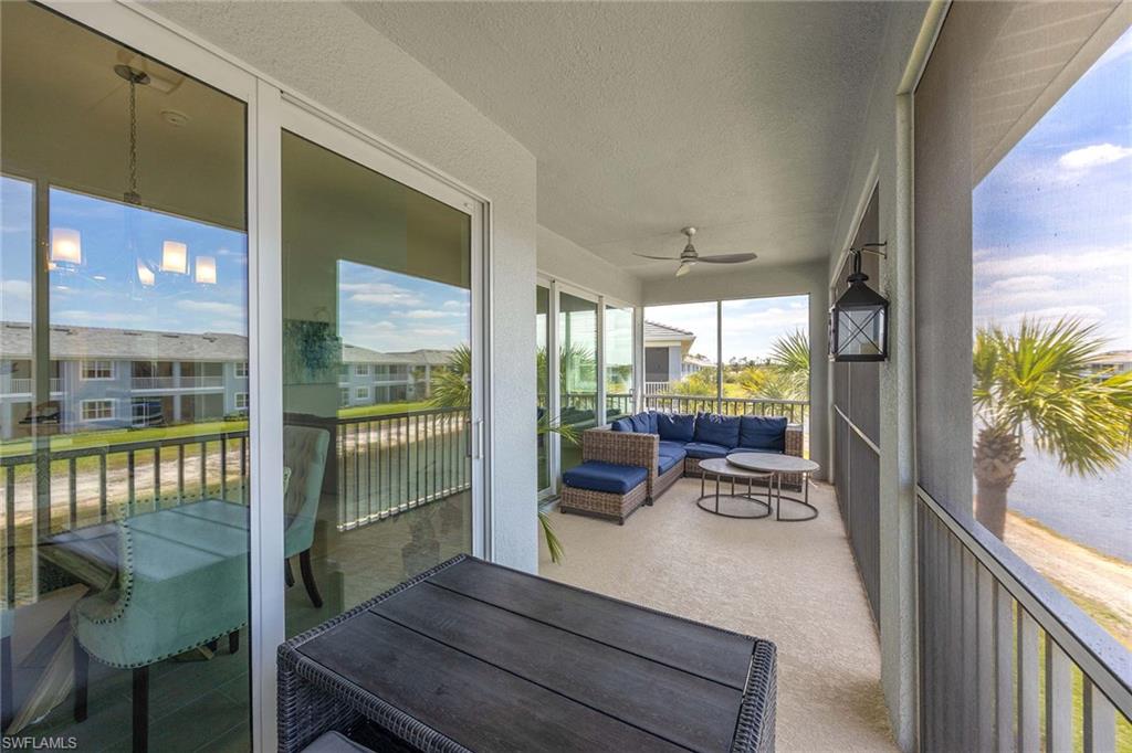 2603 Seychelles Circle, Unit 1505 Naples, FL 34112 - Photo 22 of 35 a view of a patio with table and chairs and floor to ceiling window with wooden floor