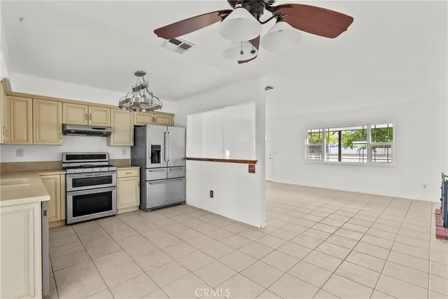 a kitchen with stainless steel appliances granite countertop a refrigerator and a stove top oven