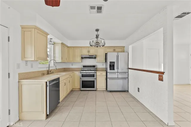 a kitchen with a sink cabinets stainless steel appliances and a window