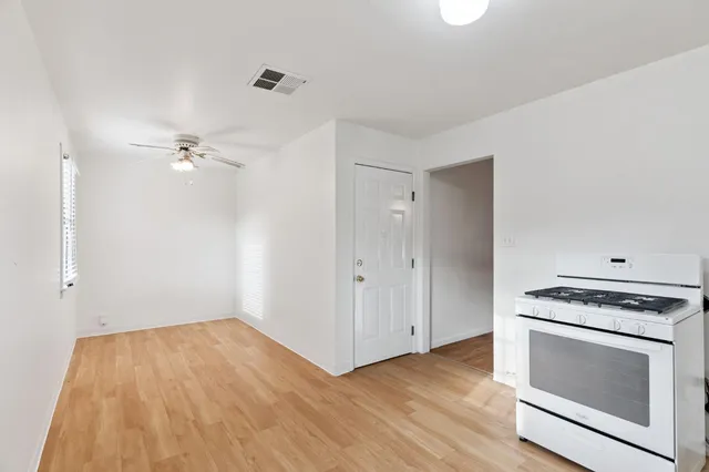 a view of a kitchen with wooden floors and appliances