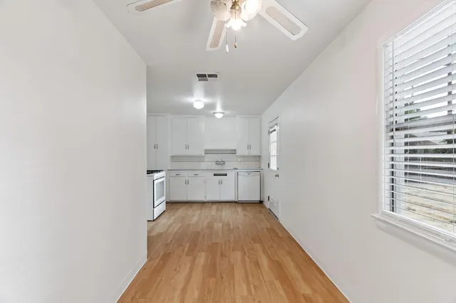 a view of a kitchen with wooden floor and a window