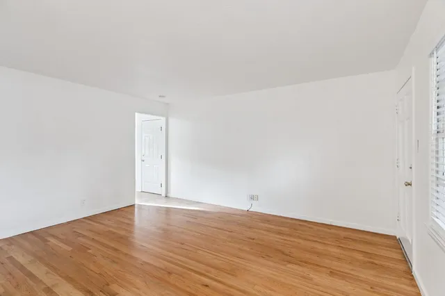 a view of an empty room with wooden floor