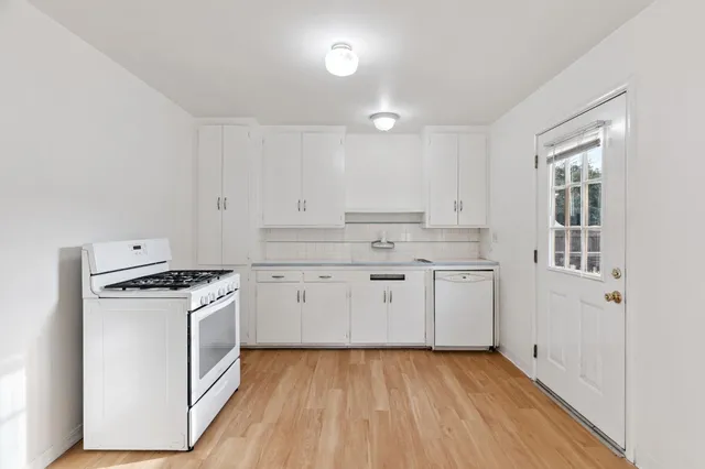 a kitchen with granite countertop a stove top oven sink and cabinets