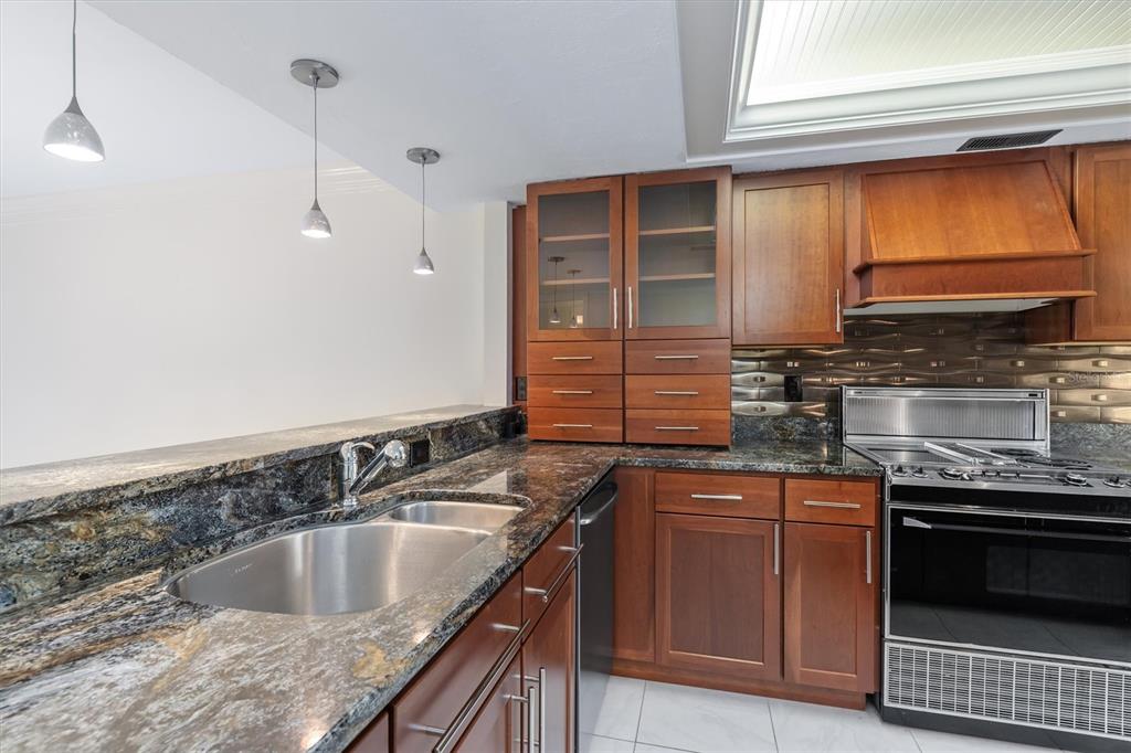 5911 Midnight Pass Road, Unit 206 Sarasota, FL 34242 - Photo 26 of 88 a kitchen with granite countertop a sink and a stove