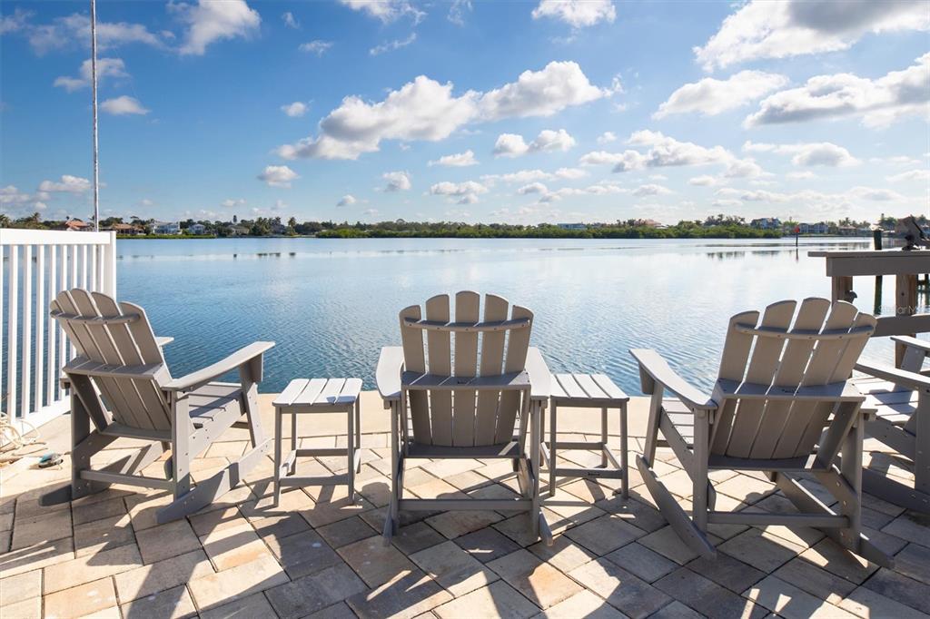 5911 Midnight Pass Road, Unit 206 Sarasota, FL 34242 - Photo 30 of 88 a view of a chairs and table on wooden deck with lake view