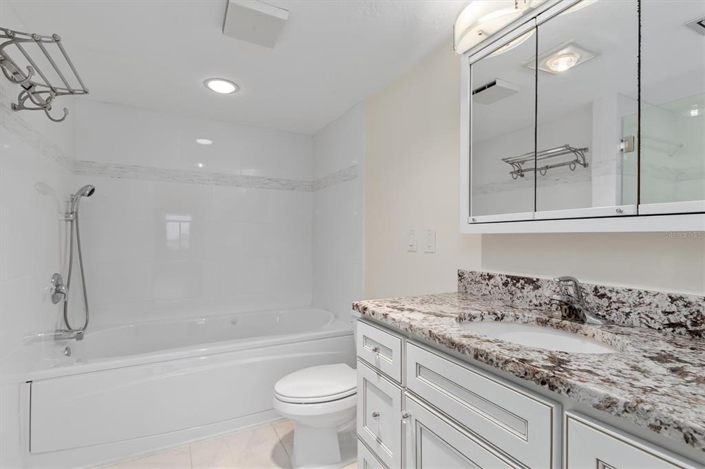 5911 Midnight Pass Road, Unit 206 Sarasota, FL 34242 - Photo 37 of 88 a bathroom with a granite countertop sink a toilet and bathtub
