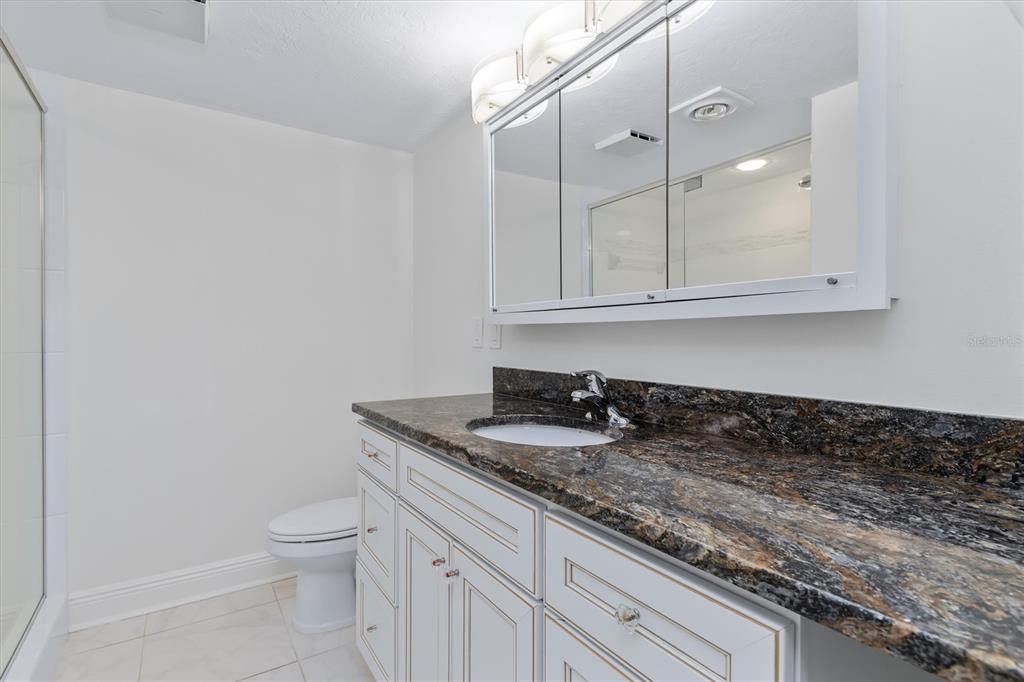 5911 Midnight Pass Road, Unit 206 Sarasota, FL 34242 - Photo 42 of 88 a bathroom with a granite countertop sink and a toilet