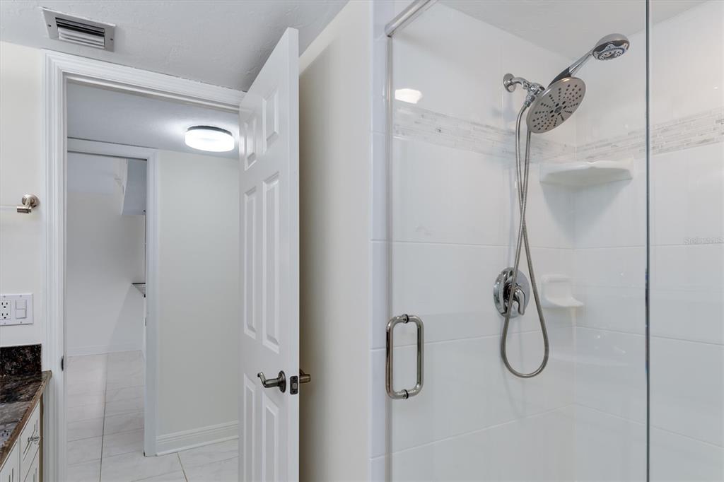 5911 Midnight Pass Road, Unit 206 Sarasota, FL 34242 - Photo 43 of 88 a bathroom with a glass shower door