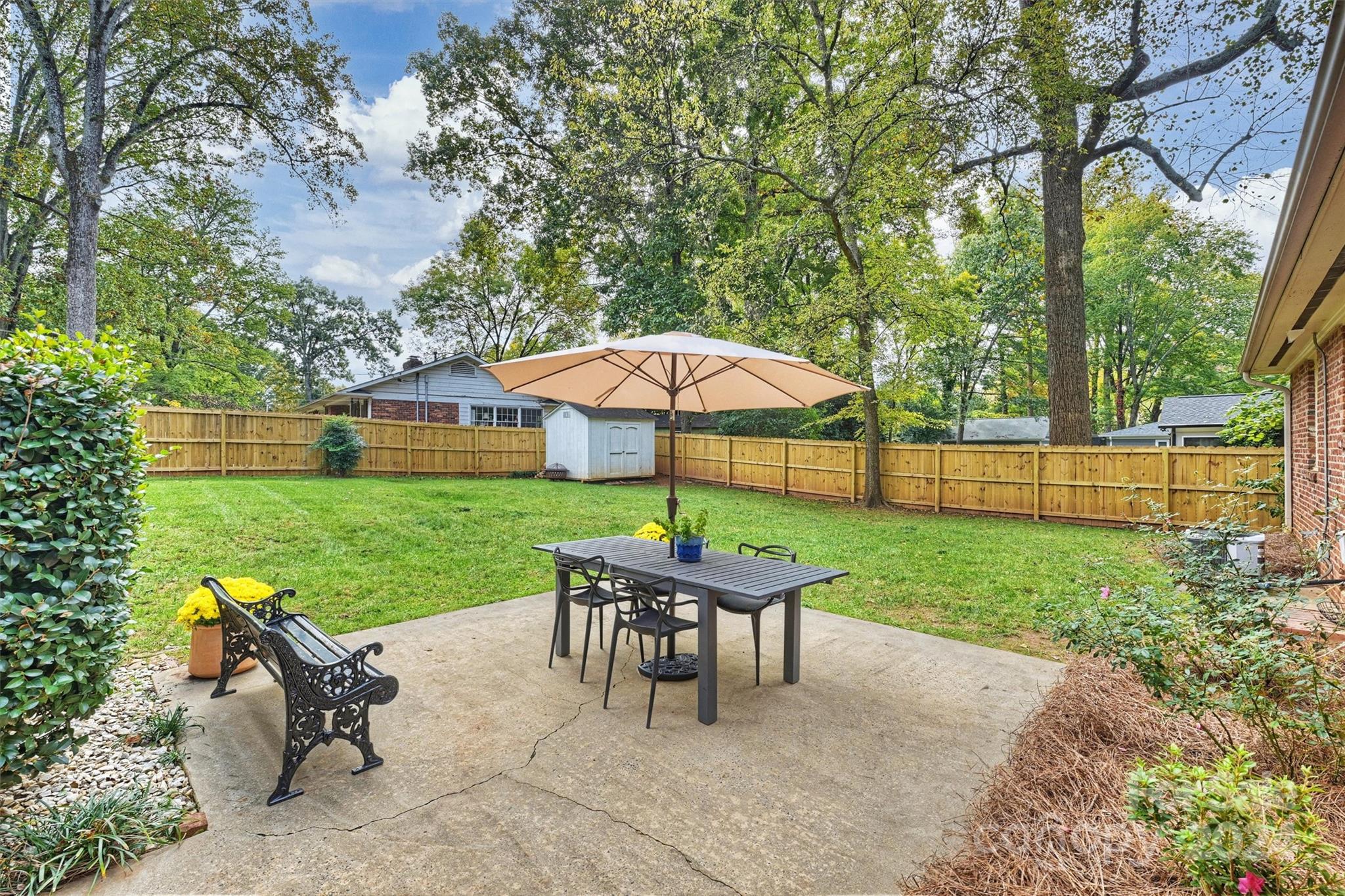 5501 Seacroft Road Charlotte, NC 28210 - Photo 31 of 37 a view of a backyard with a table and chairs under an umbrella