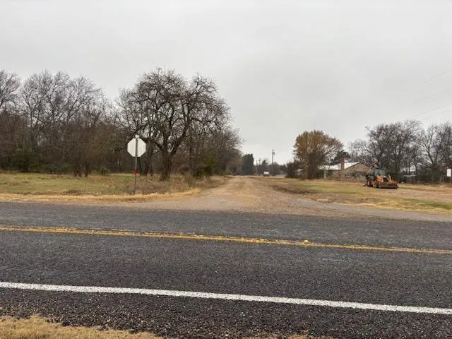 a view of a field with trees in background