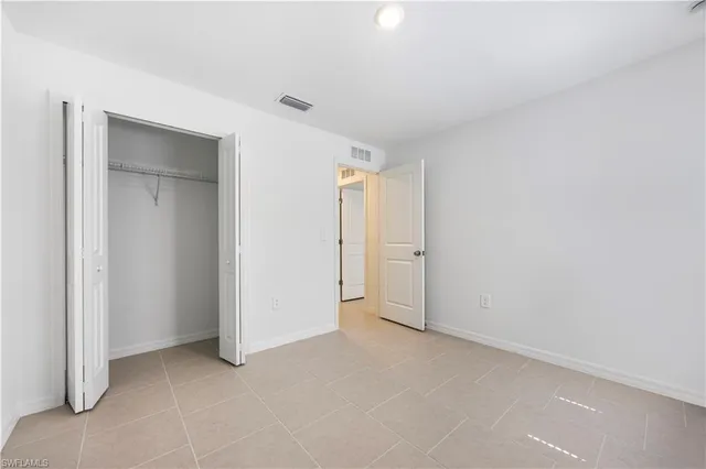 an empty room with closet and a bathroom