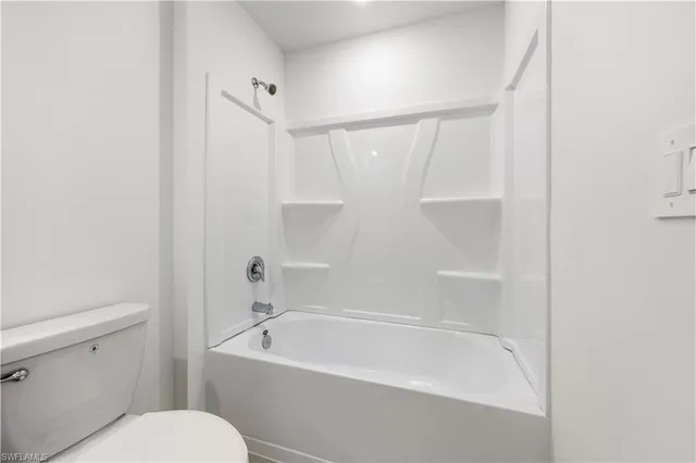 a white bath tub sitting next to a white toilet