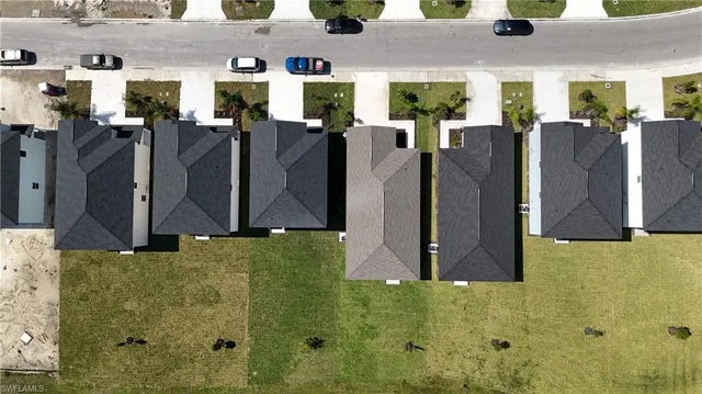 an aerial view of residential houses with outdoor space and pool
