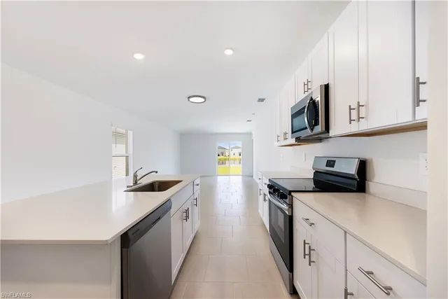 a kitchen with stainless steel appliances a stove a sink a microwave and a refrigerator