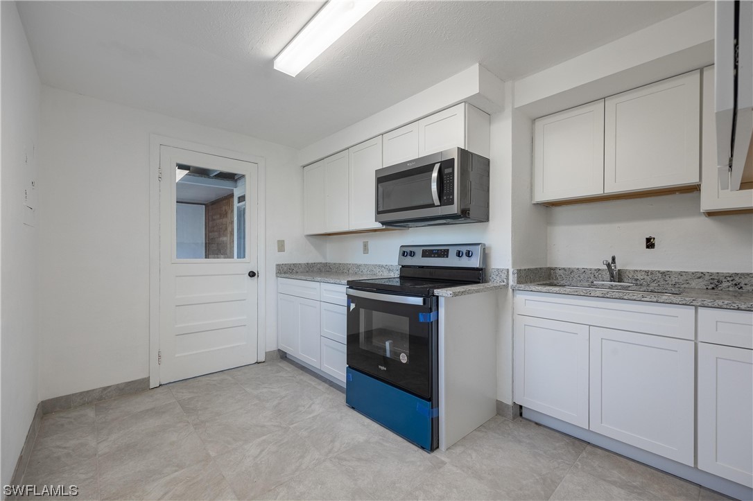 1338 Old Bridge Road North Fort Myers, FL 33917 - Photo 16 of 33 a kitchen with granite countertop white cabinets stainless steel appliances and a sink