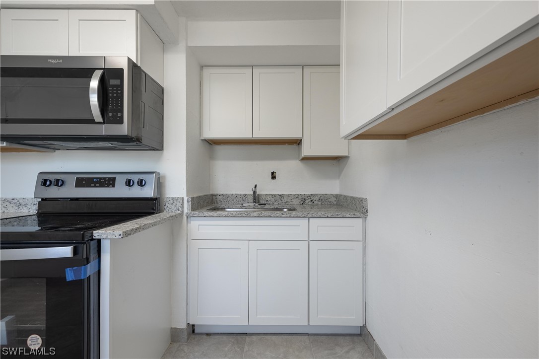 1338 Old Bridge Road North Fort Myers, FL 33917 - Photo 17 of 33 a kitchen with stainless steel appliances granite countertop a sink and a microwave