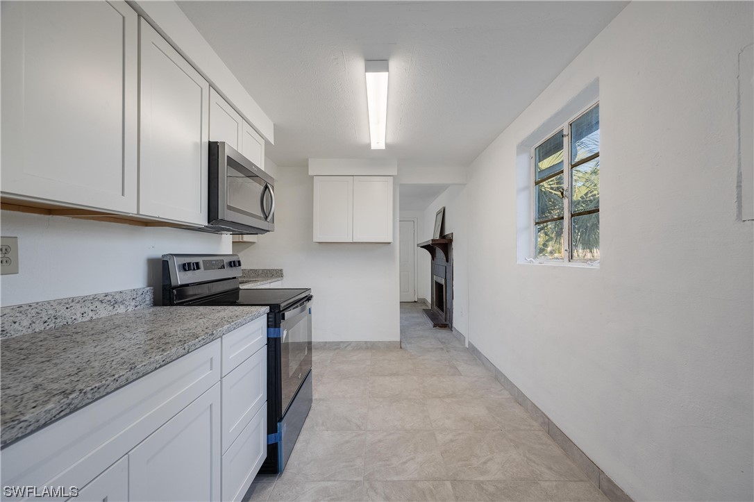 1338 Old Bridge Road North Fort Myers, FL 33917 - Photo 18 of 33 a kitchen with stainless steel appliances granite countertop a stove a sink and a microwave