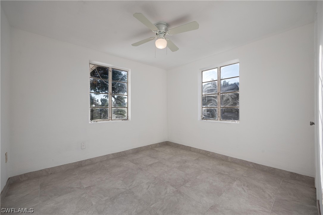1338 Old Bridge Road North Fort Myers, FL 33917 - Photo 9 of 33 an empty room with windows and ceiling fan