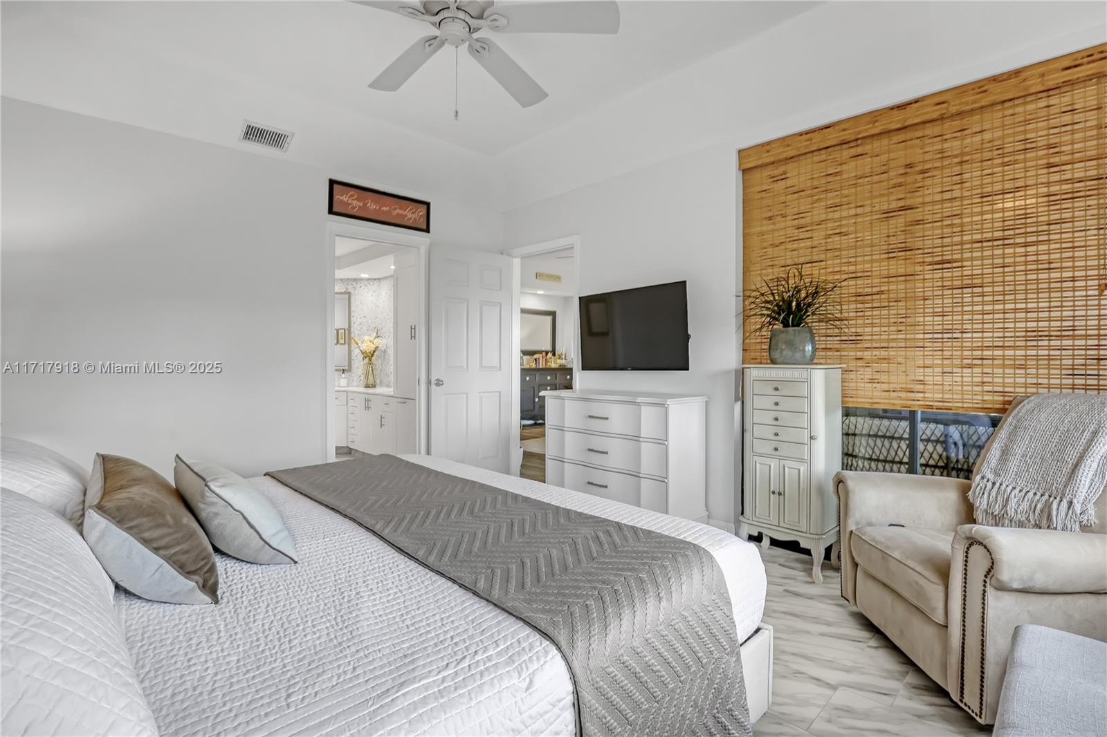 6102 Southeast Landing Way, Unit 2 Stuart, FL 34997 - Photo 26 of 44 a bedroom with a bed and a flat screen tv