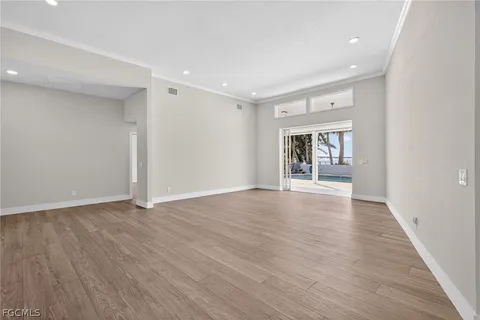 a view of an empty room with wooden floor