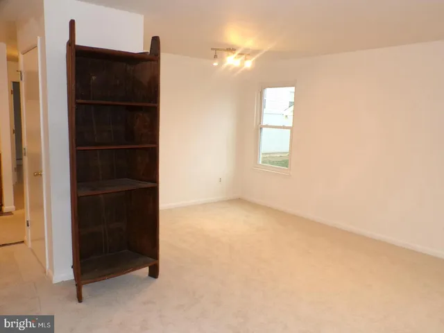 an empty room with a closet and a window