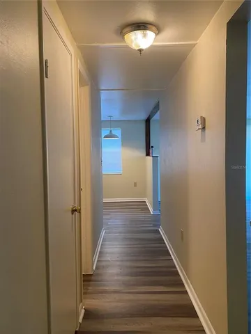 a view of a hallway with wooden floor and staircase