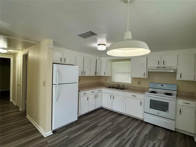 a kitchen with stainless steel appliances a sink a stove a refrigerator and cabinets