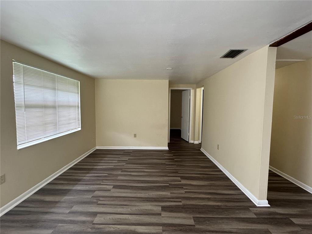 12007 Homerville Lane Seffner, FL 33584 - Photo 4 of 15 a view of an empty room with wooden floor and a window