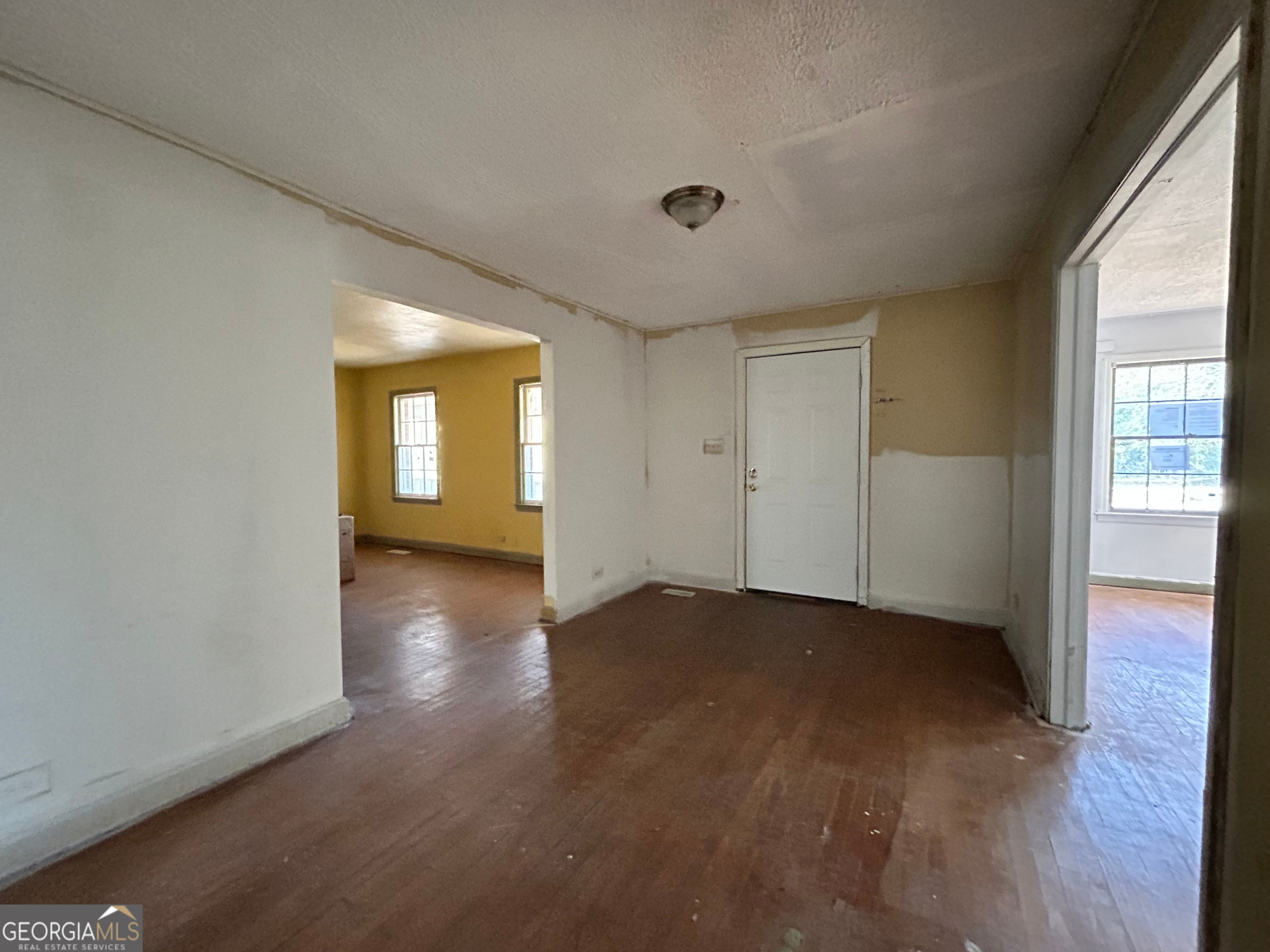 806 Magnolia Drive Macon, GA 31217 - Photo 9 of 25 an empty room with wooden floor and windows