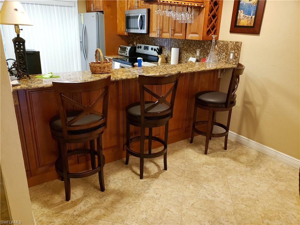 4031 Ice Castle Way, Unit 3303 Naples, FL 34112 - Photo 2 of 18 a dinning table sitting in a kitchen next to a window