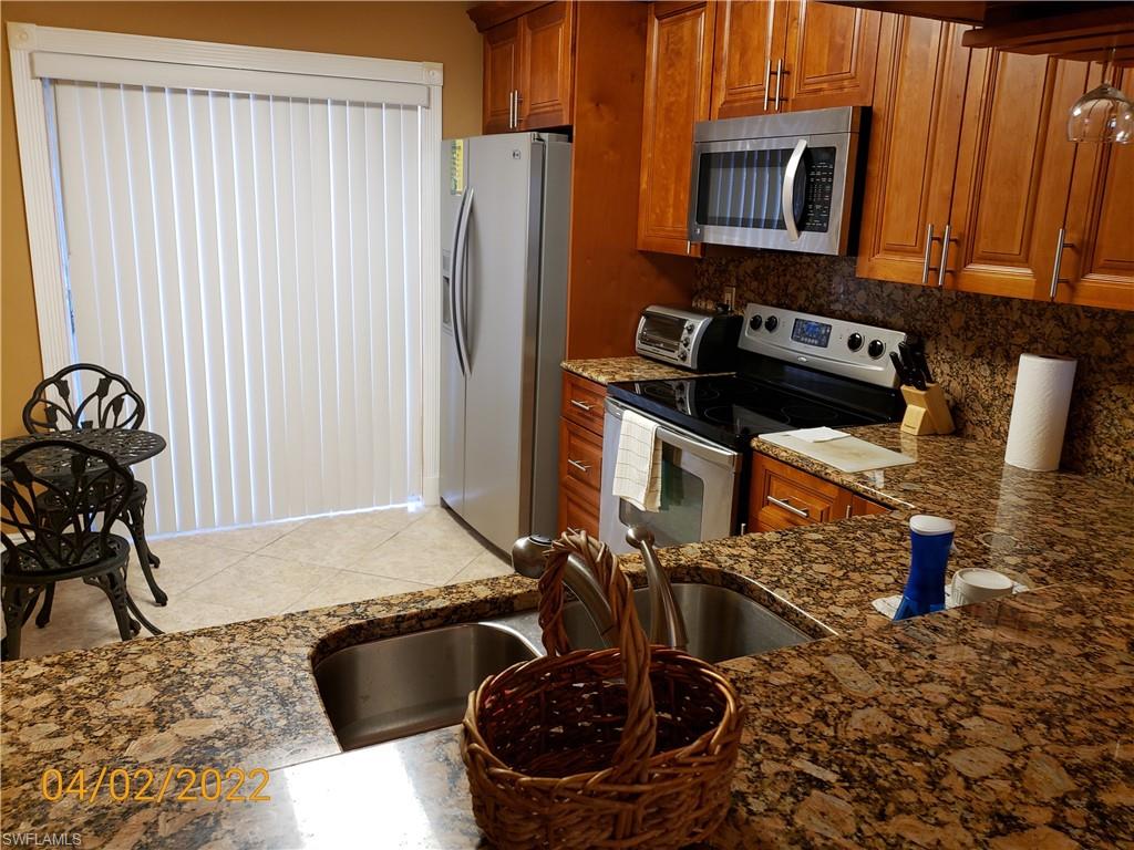 4031 Ice Castle Way, Unit 3303 Naples, FL 34112 - Photo 3 of 18 a kitchen with a stove and a refrigerator