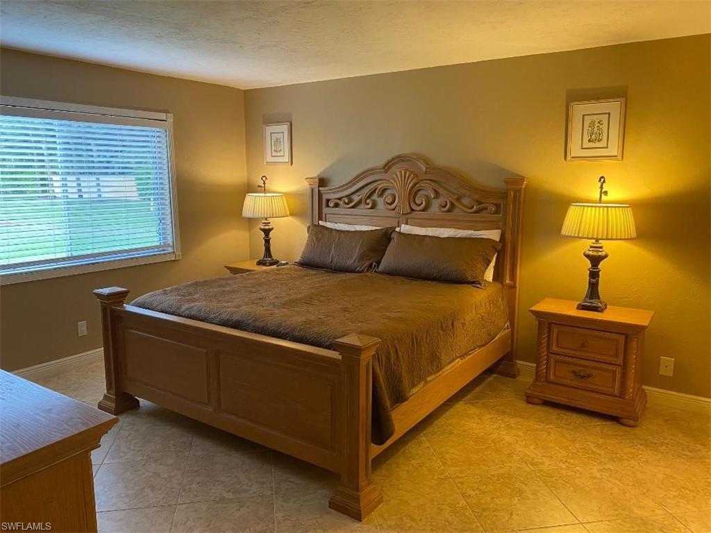 4031 Ice Castle Way, Unit 3303 Naples, FL 34112 - Photo 6 of 18 a bedroom with a bed and lamp