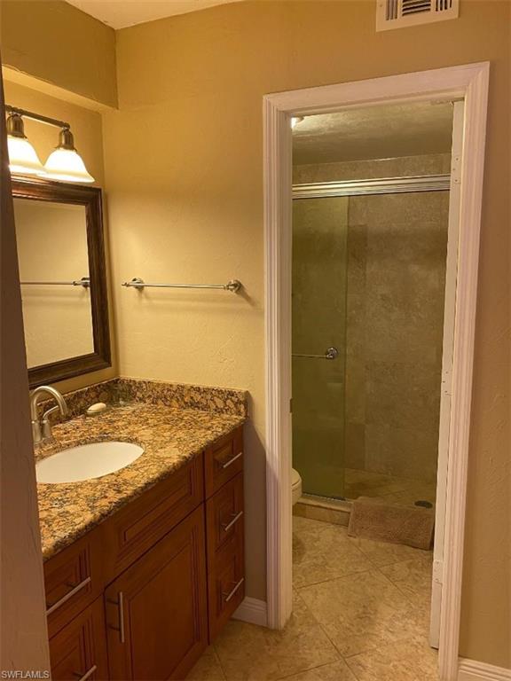 4031 Ice Castle Way, Unit 3303 Naples, FL 34112 - Photo 7 of 18 a bathroom with a granite countertop sink a mirror and shower