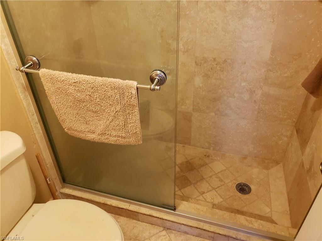 4031 Ice Castle Way, Unit 3303 Naples, FL 34112 - Photo 8 of 18 a bathroom with a granite countertop shower and a toilet