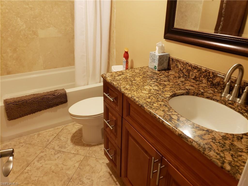 4031 Ice Castle Way, Unit 3303 Naples, FL 34112 - Photo 10 of 18 a bathroom with a granite countertop sink and a mirror