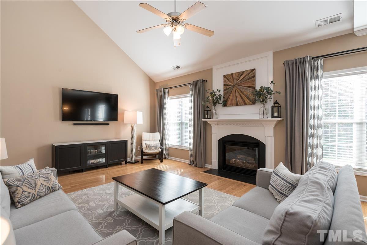 7724 Braefield Drive Raleigh, NC 27616 - Photo 13 of 27 a living room with furniture a flat screen tv and a fireplace