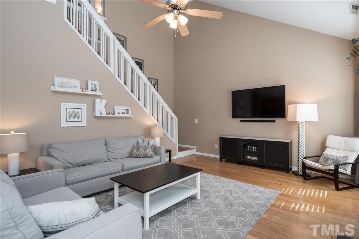 7724 Braefield Drive Raleigh, NC 27616 - Photo 14 of 27 a living room with furniture a fireplace and a flat screen tv